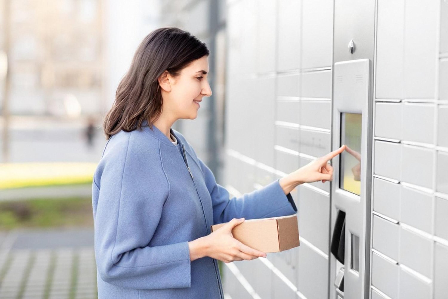 Woman collecting a package from a secure locker system, illustrating access control